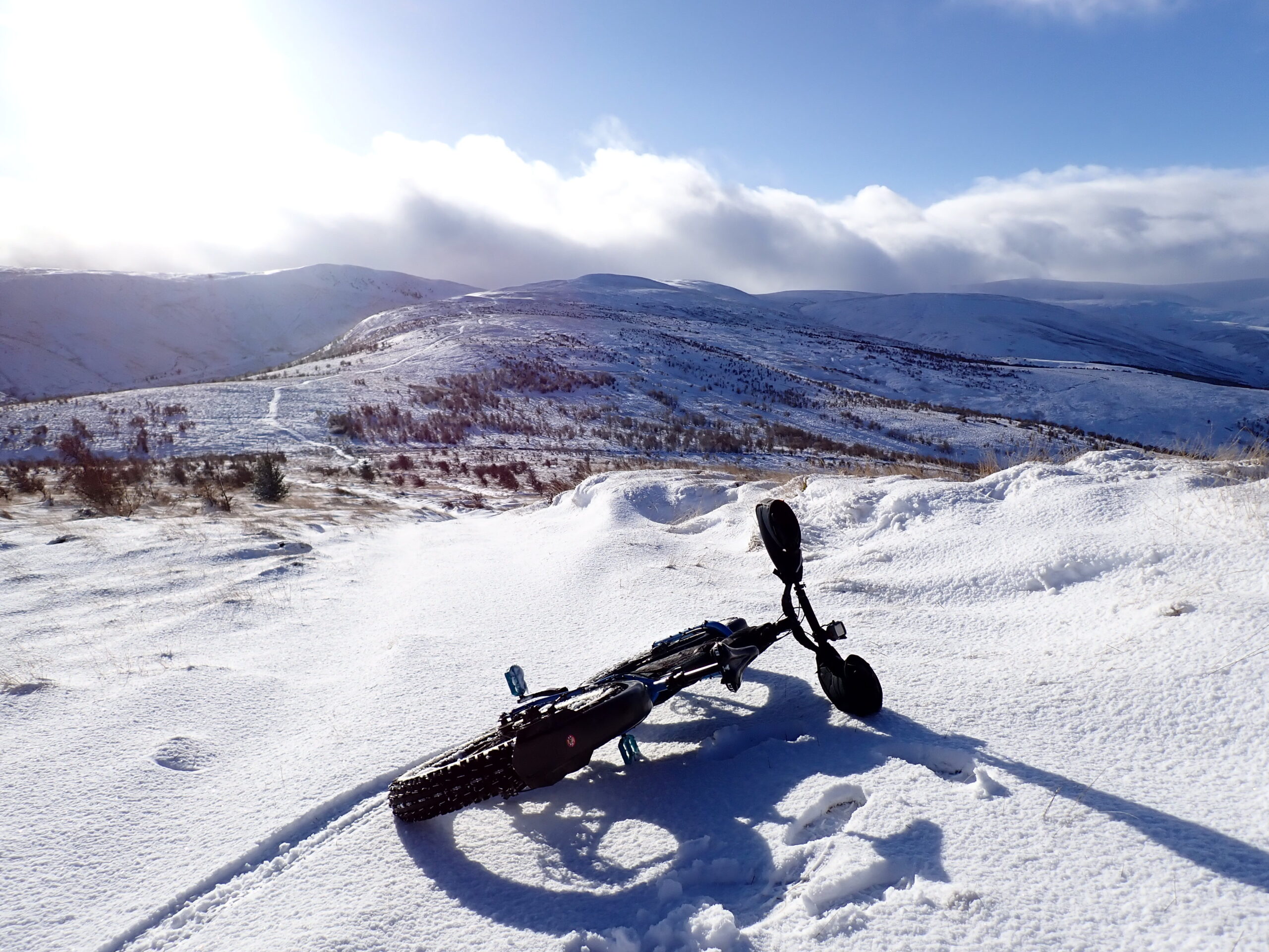 A fat bike on its side in snow in the Lowland Hills outside Stirling Scotland.