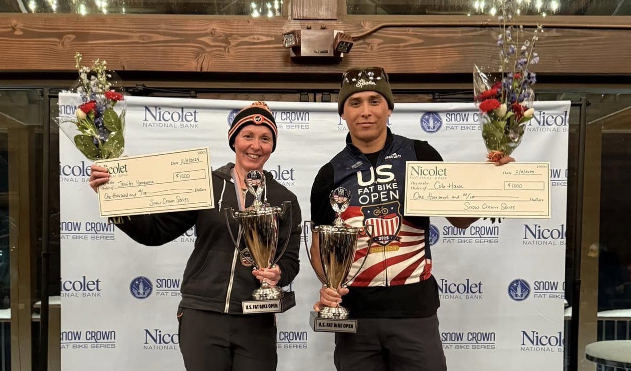 Photo of US Fat Bike Open overall winners Jennifer Youngwerth and Cole House holding flowers and checks for $1,000.
