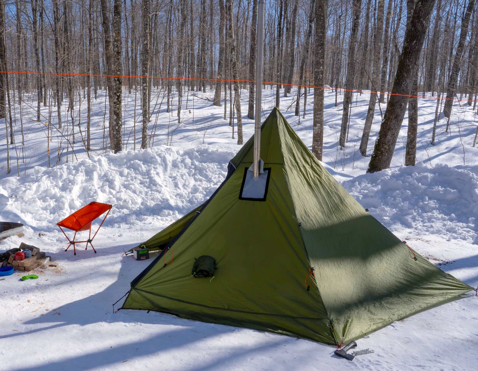 Tipi style hot tent set up in a winter setting