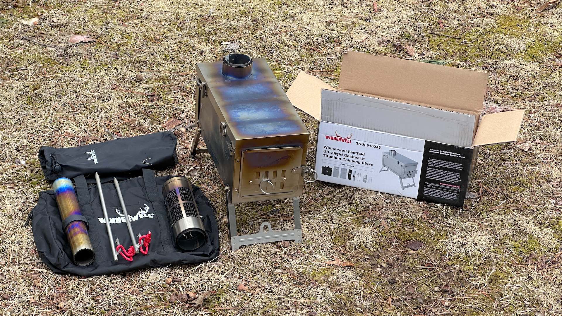 Assembled Winnerwell Fastfold Titanium Wood Stove next to box and bag