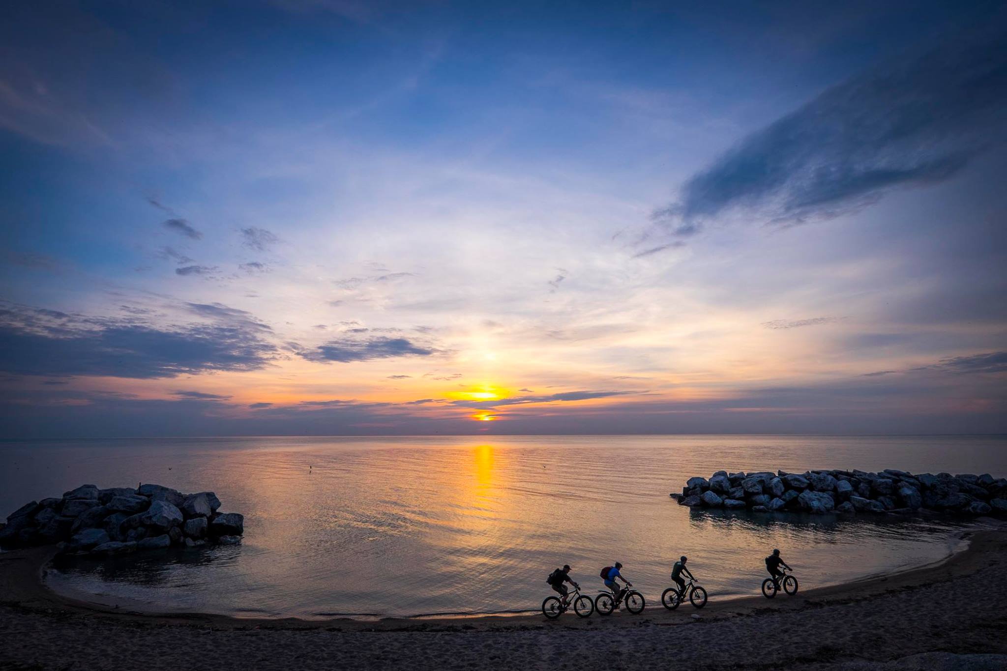four people ride fat bikess on Kode Beach in Shorewood, WI