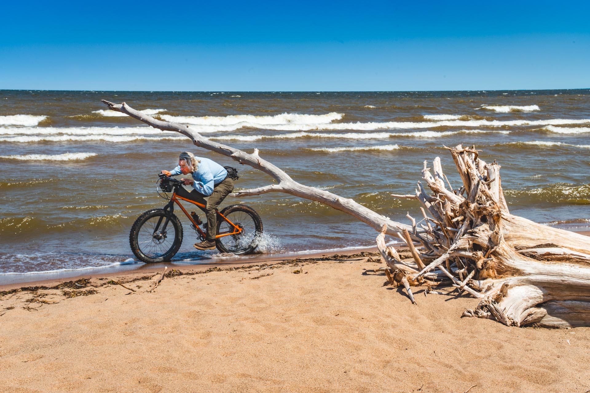 man beach riding along lake superior on fat bike